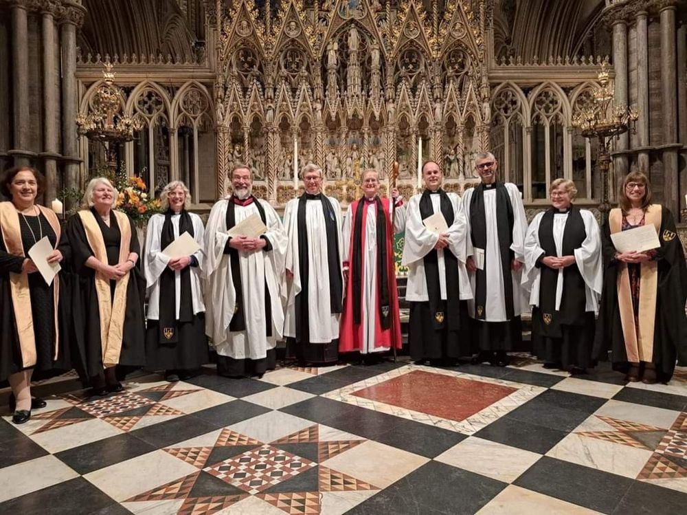 Several people in clerical robes standing in an ornate cathedral.