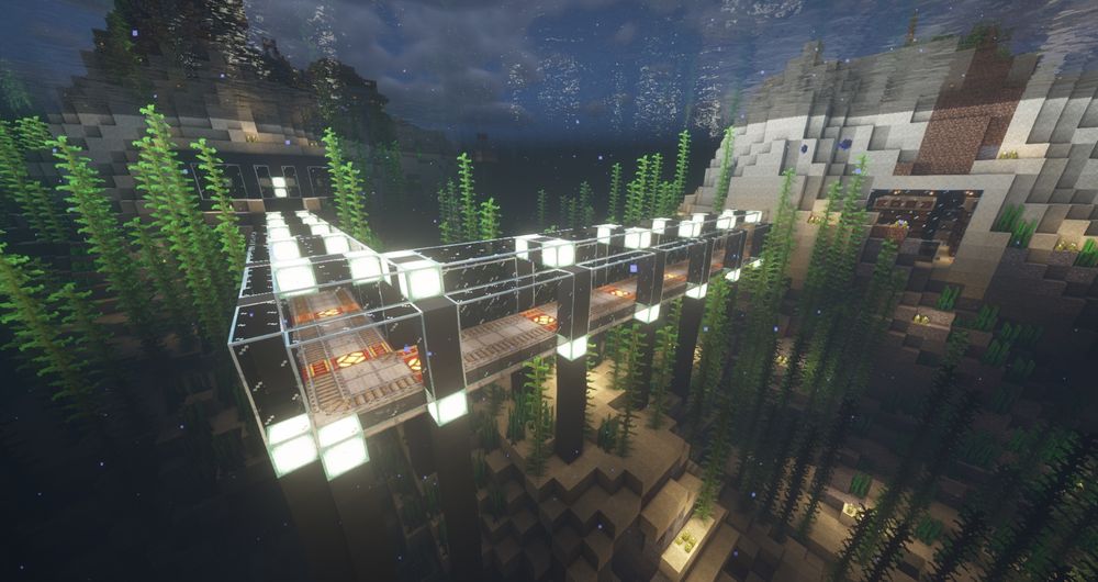 Image shows a glass underwater tunnel decorated with sea lanterns that encases a minecart railway system. This passageway  connects the two nearby islands together underground.