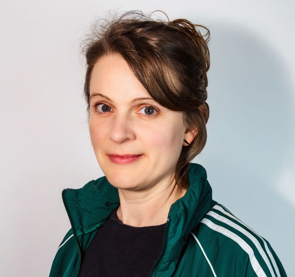 ein Porträtfoto von Kadda in grüner Sportjacke