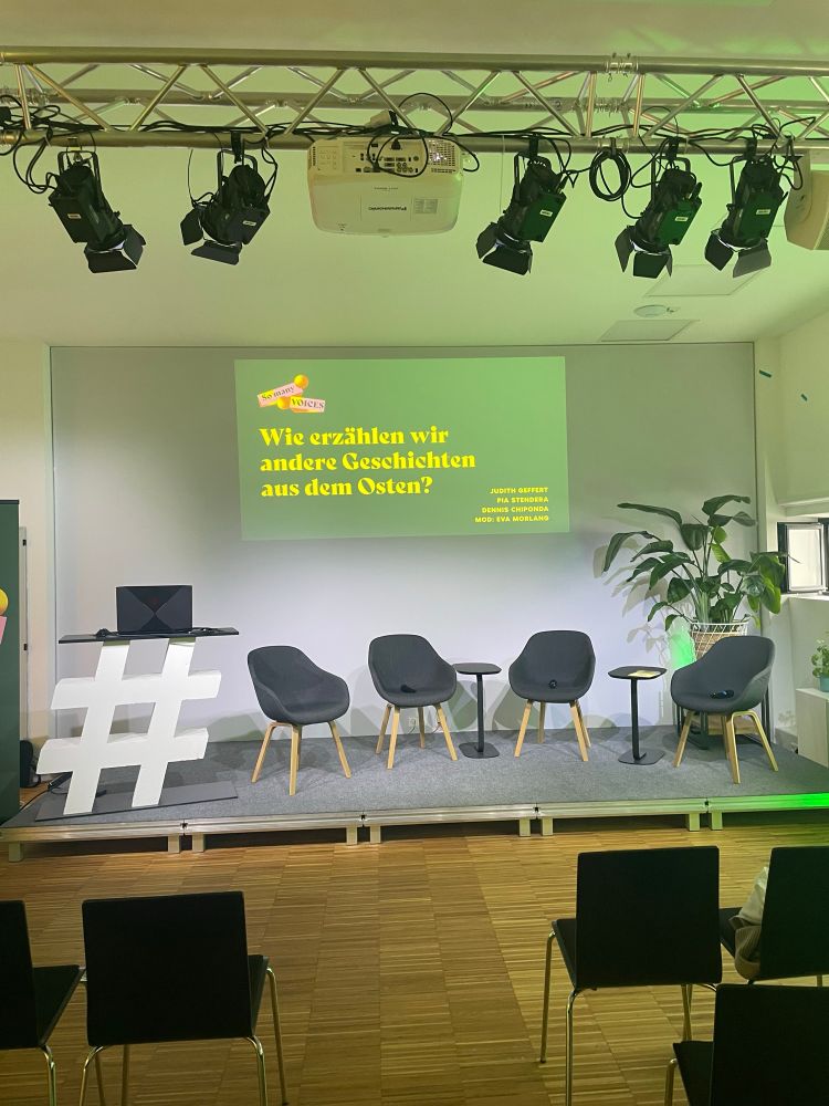 die leere Bühne wartet auf die Teilnehmenden der Podiumsdiskussion zu Podcasts über/aus und mit dem Osten