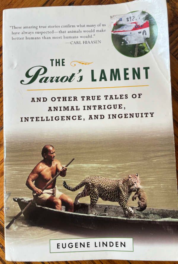 Book cover: The Parrot's Lament: And Other True Tales of Animal Intrigue, Intelligence, and Ingenuity by Eugene Linden (Plume/Penguin, 1999). Includes a photo of a human rowing a boat that contains a female leopard holding her cub. 