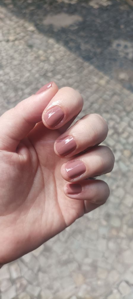 Unhas pintadas de marrom claro.