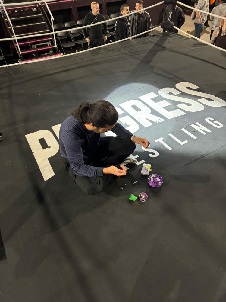 Me, sat cross legged sewing up the canvas on a wrestling ring