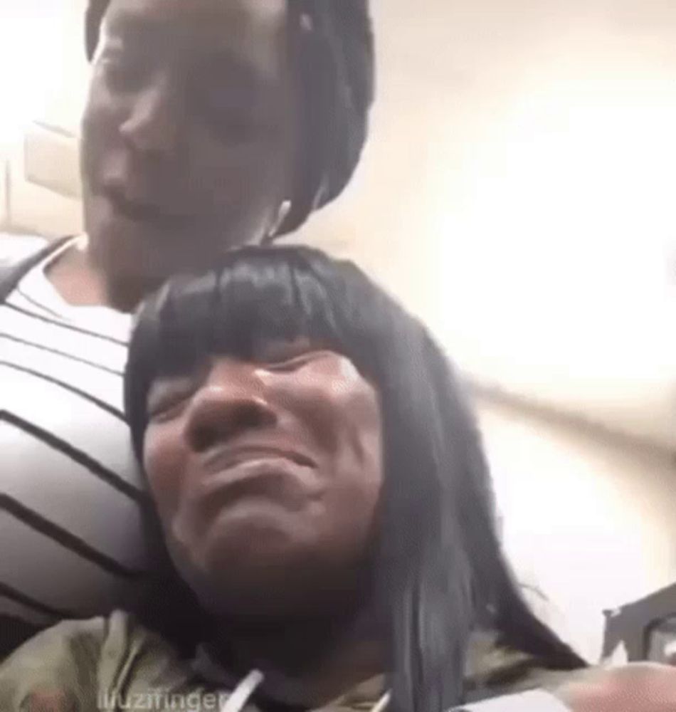 a woman is crying while sitting next to another woman who is making a funny face .