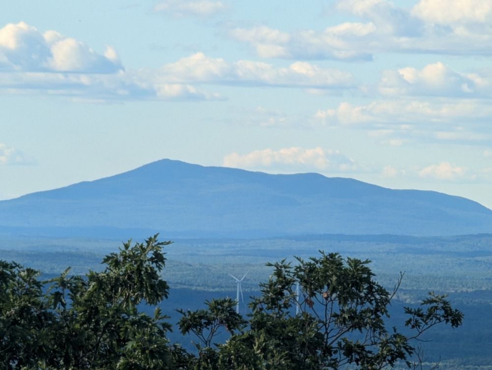 Mount Monadnock's profile against the sky with puffy white clouds