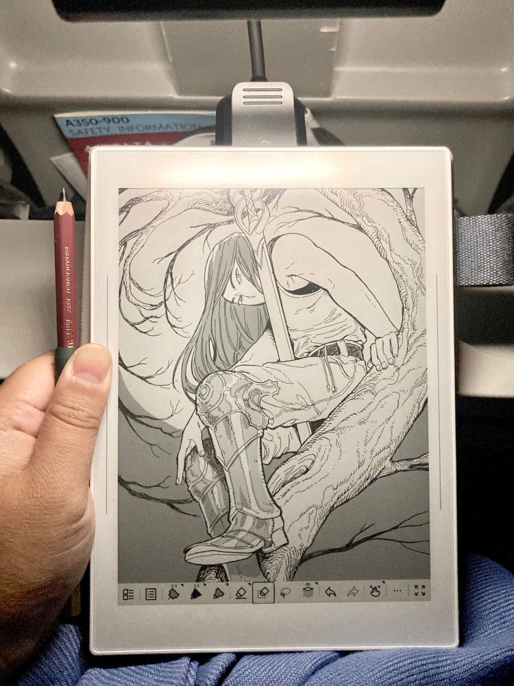 A poorly lit photo in an airplane of my drawing of a person leaning over on a branch holding a sword and wearing armor plate grieves.
