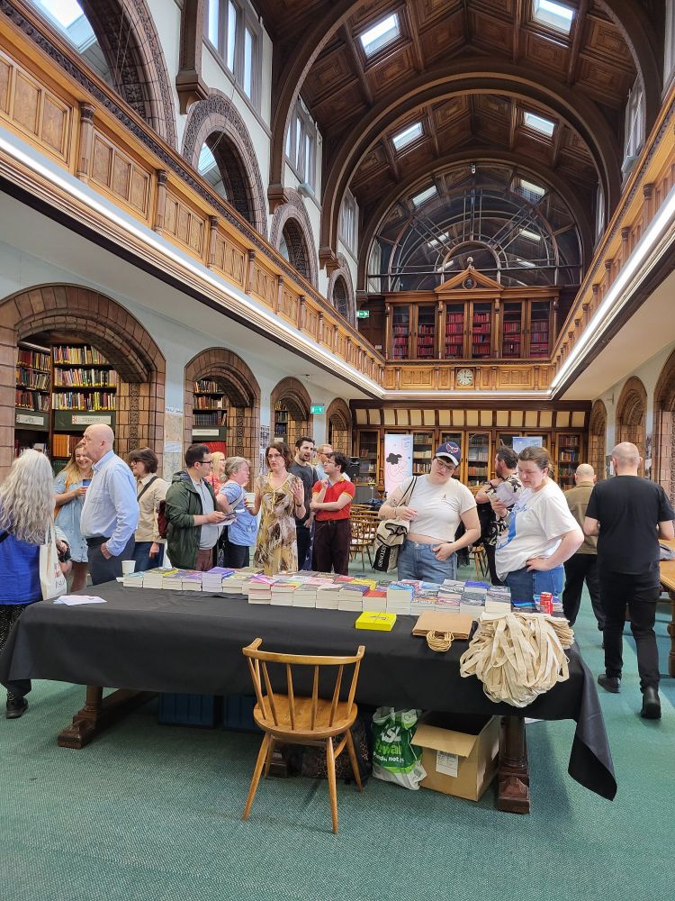 A group of people looking at books at a book event for Leeds Lit Fest