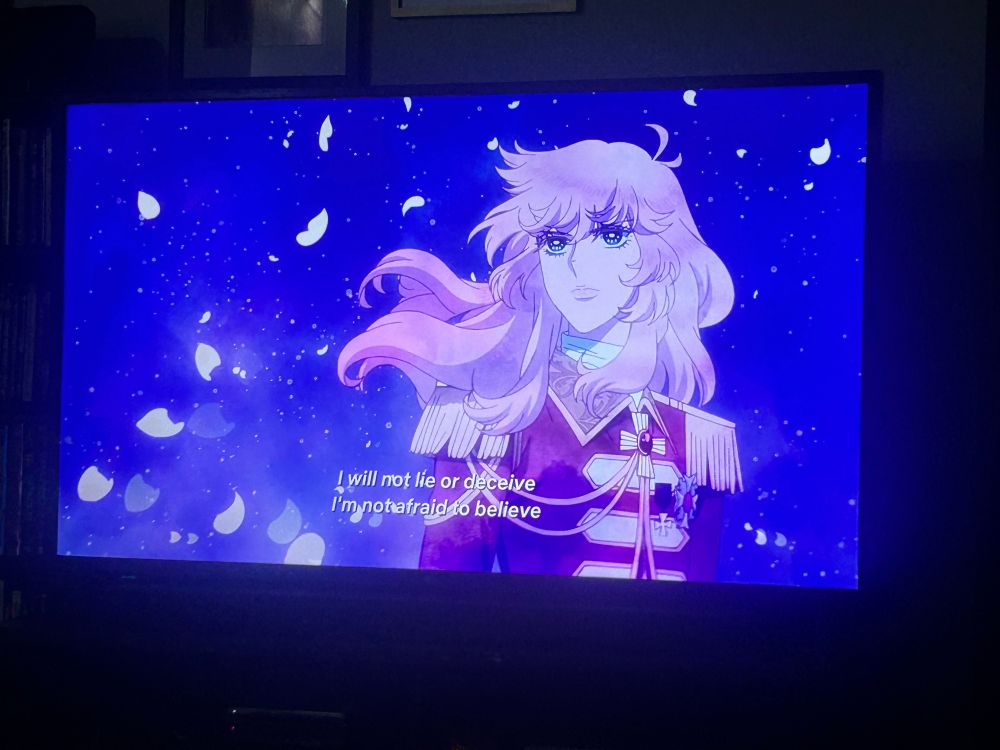 A picture of my tv showing the Rose of Versailles on Netflix. It is very anime opening 3 coded with Lady Oscar in front of a nebulous background with petals dancing in the breeze