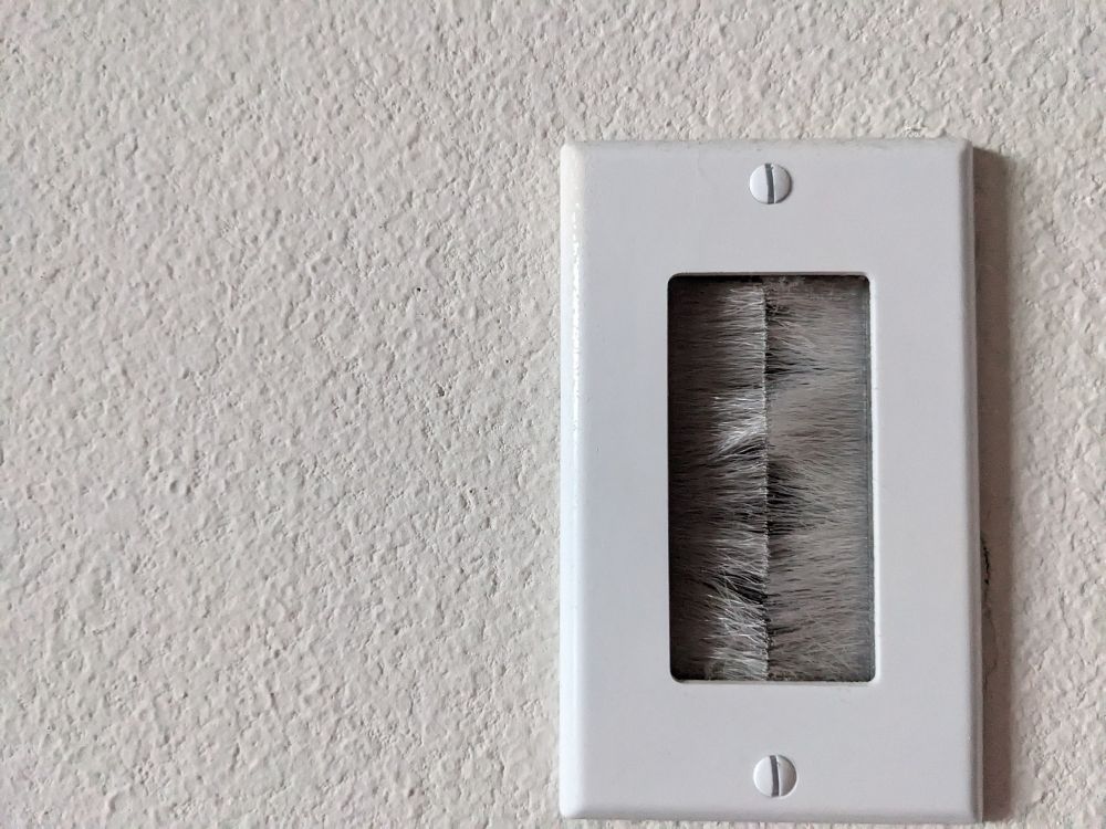 A plate on a wall with small brushes on either side