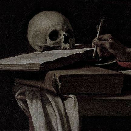 Una imagen oscura con un fondo negro. Se ve una mesa, varios libros, una calavera encima de estos y una mano con una pluma a la derecha.