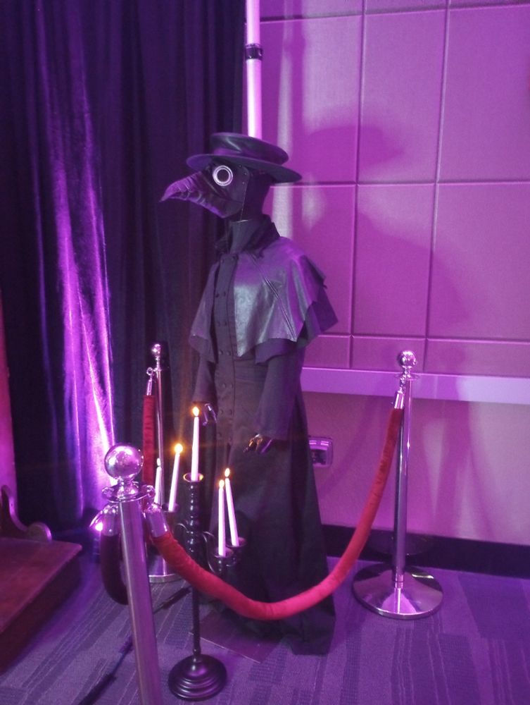 A doctor costume is displayed automatican behind Red Velvet rope