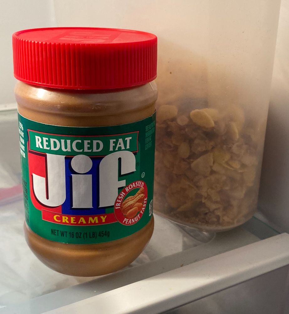 Jar of peanut butter in a refrigerator.