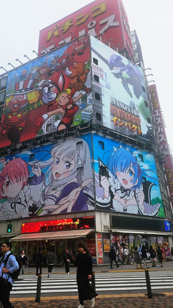 Picture of a street in Shinjuku, billboards are covered in anime artwork