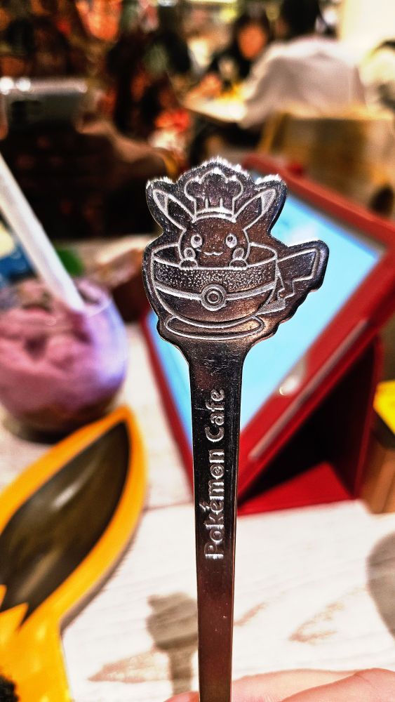 Close up of cutlery at the Pokemon Cafe, the fork has a chef Pikachu peaking out of a pokeball at the end and has Pokemon Cafe engraved on the handle
