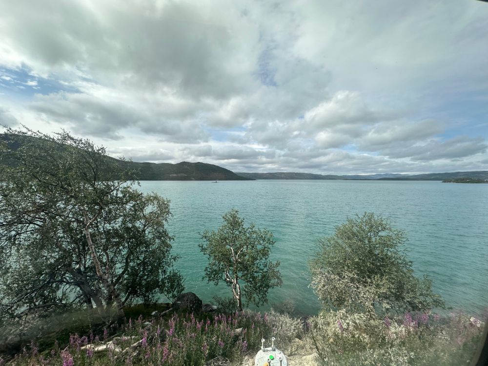A pale green lake under a white cloudy sky.