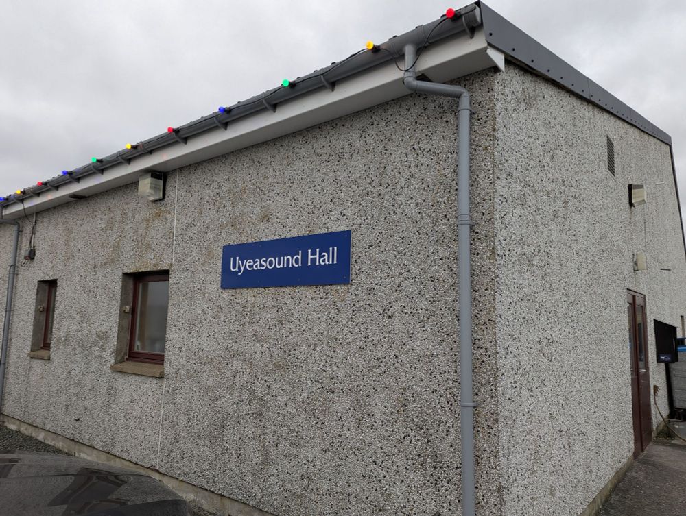 The outside of a village hall. The sign reads "Uyeasound Hall"