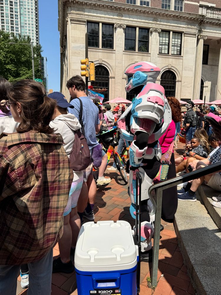 A person dressed as a transformer in trans flag colors at Philly Pride