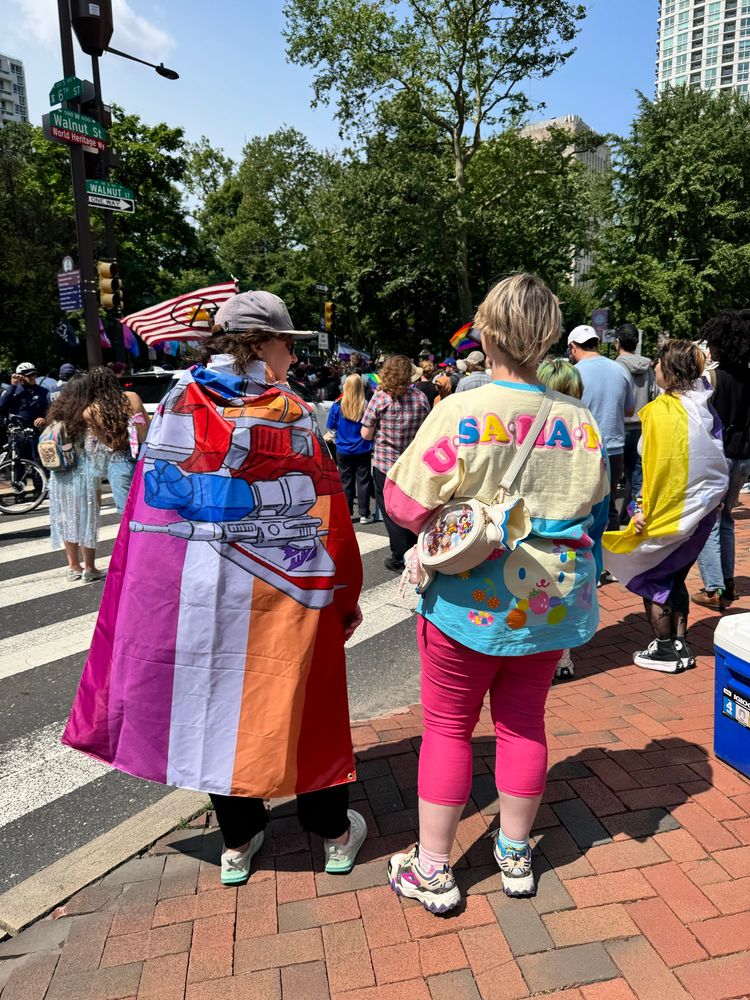 Two people in flag decor at Philly Pride
