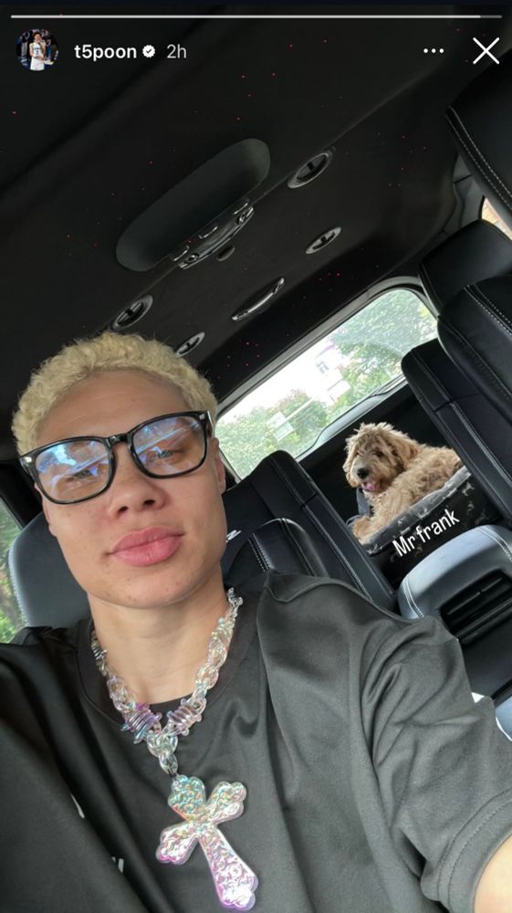 Natisha Hiedeman in her car wearing a black tshirt and a large with her shaggy dog in the back seat.