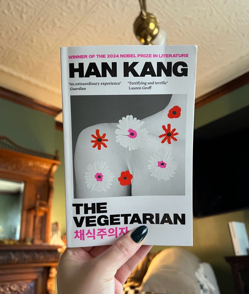Hand holding up book titled “The Vegetarian”