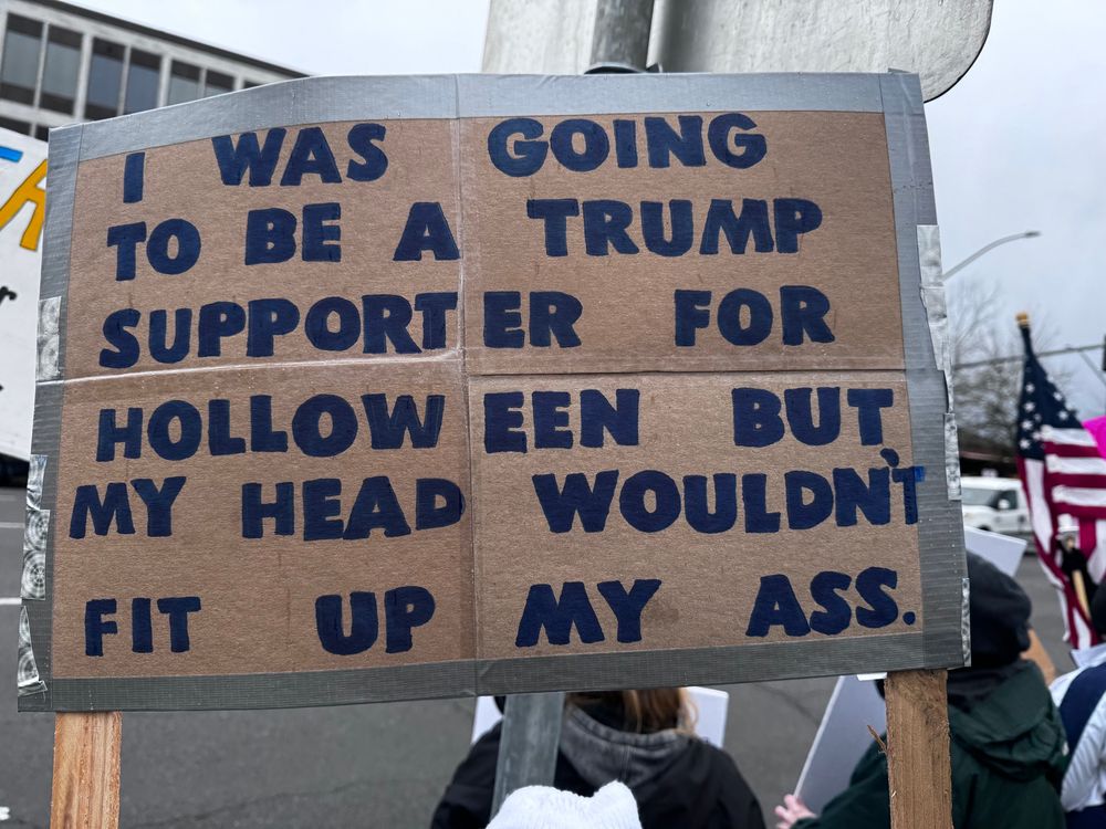 A sign reading "I was going to be a trump supporter for holloween but my head wouldn't fit up my ass"