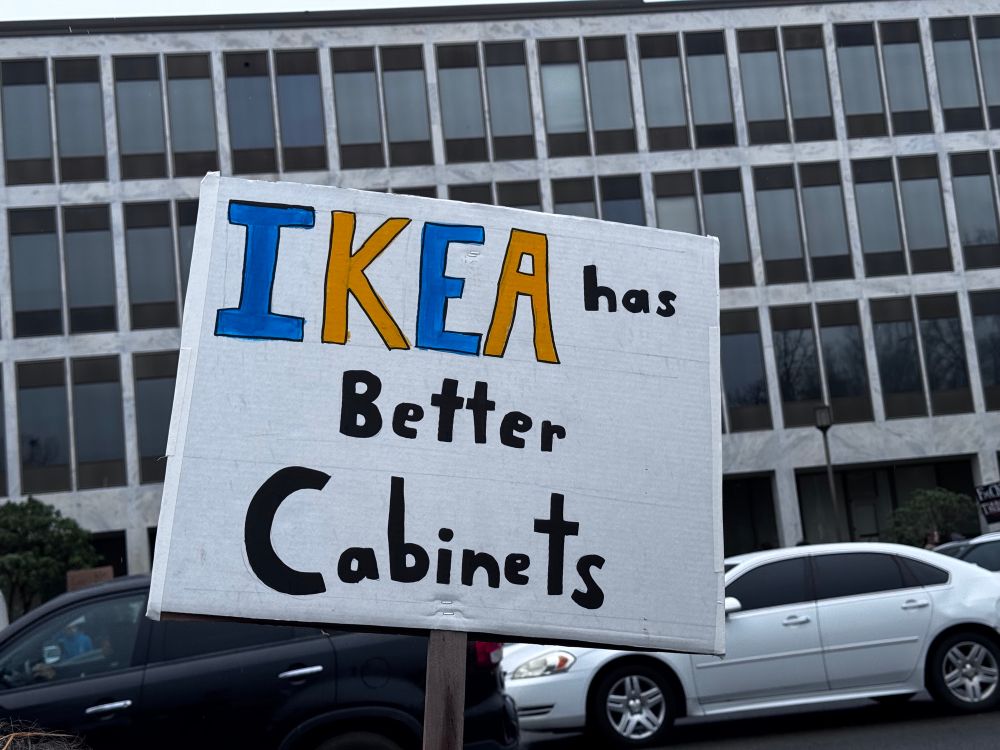 A sign reading "IKEA has better cabinets"