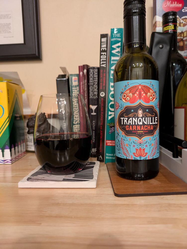 Glass of red wine next to half bottle 