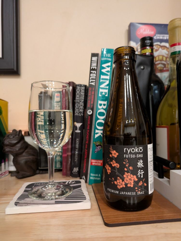 Sherry glass of pale sake next to half bottle 
