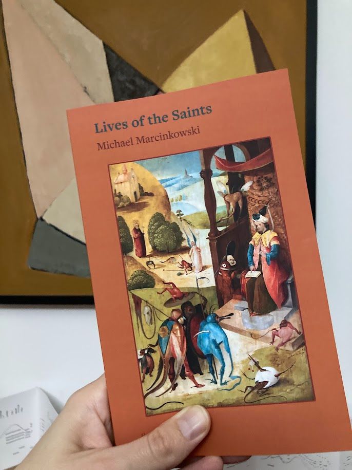 Hand holding a copy of LIVES OF THE SAINTS.