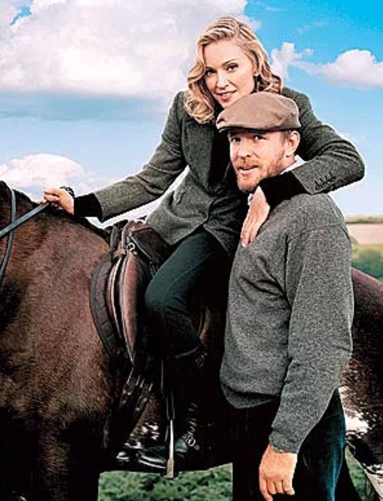 Madonna, who is from Michigan like me, looking Britishish on a horse with her arm around Guy Ritchie during her fake British Accent era.