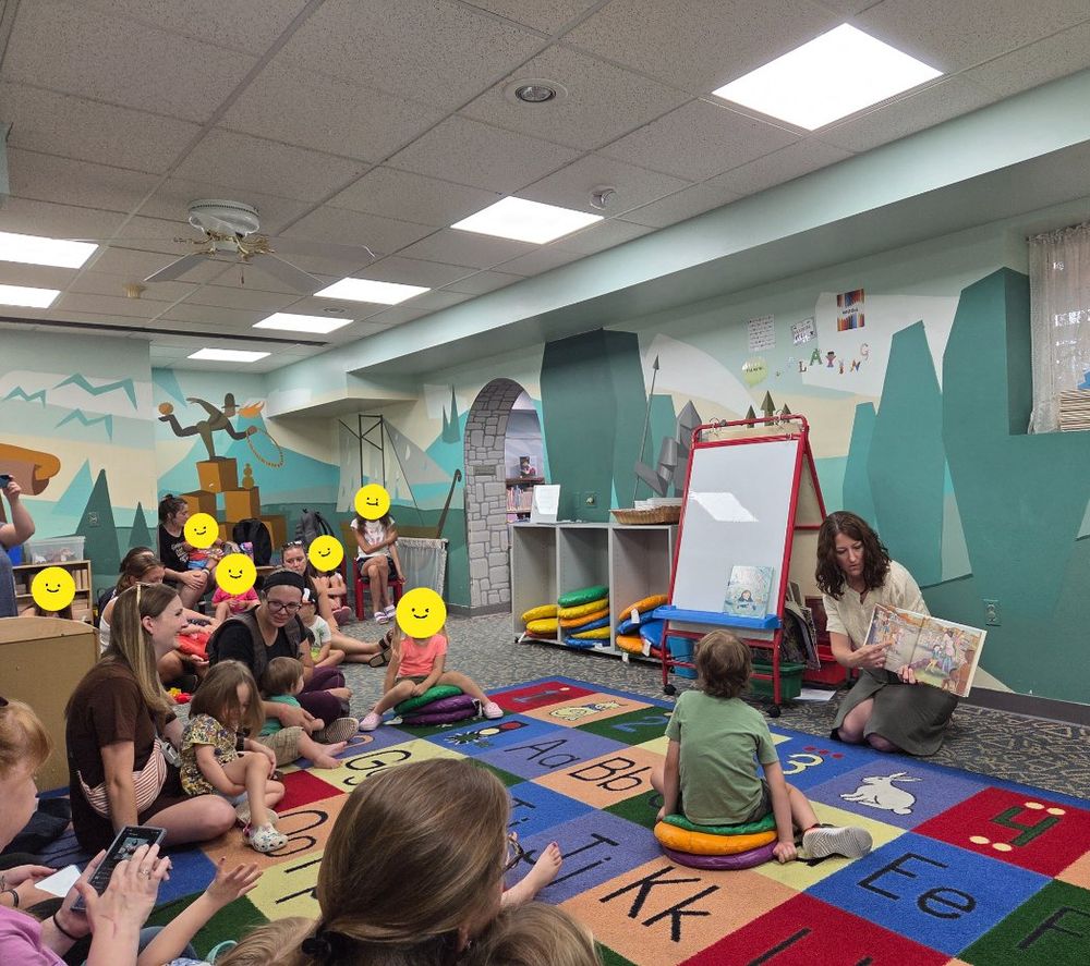 a woman reading to kids and parents