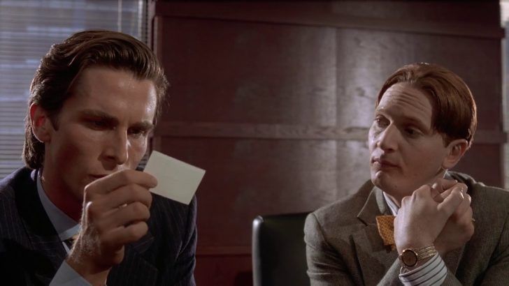 Scene from American Psycho, where members of the upper management inspect and rate (and envy) each others business cards. They are observing every detail down to the color of the card board. Patrick Bateman prefers bone instead of eggshell or cream.