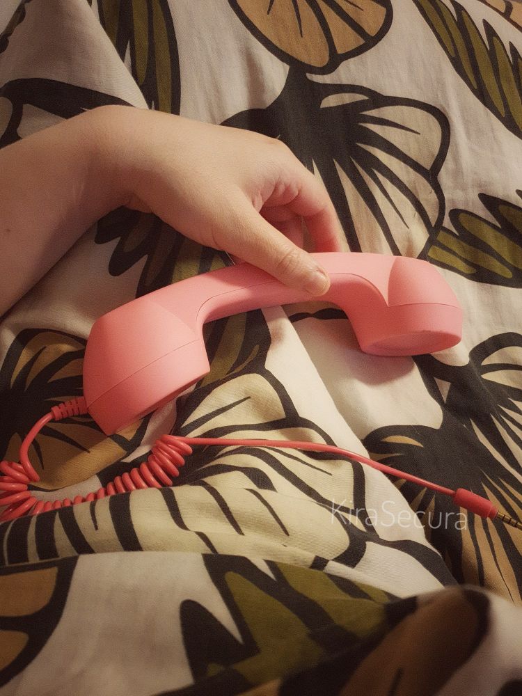 A hand holding an retro phone except it is a mobile phone accessory 