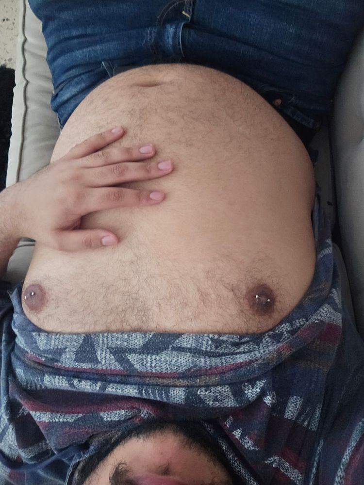 Lating down on the sofa showing my belly.
