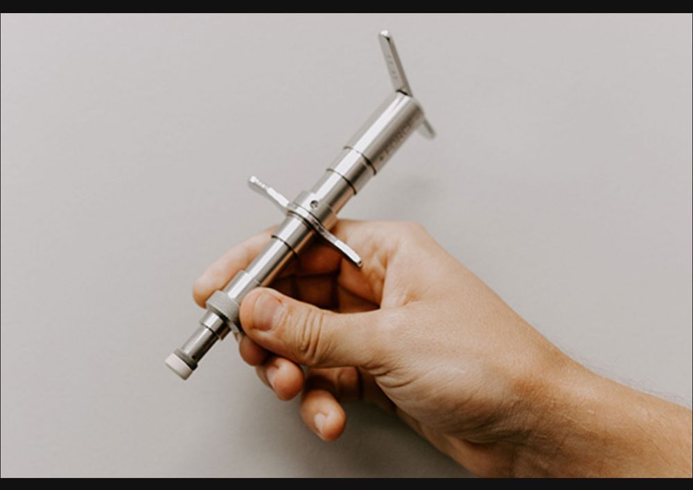 A hand holding an integrator, used in neurological  chiropractic care.