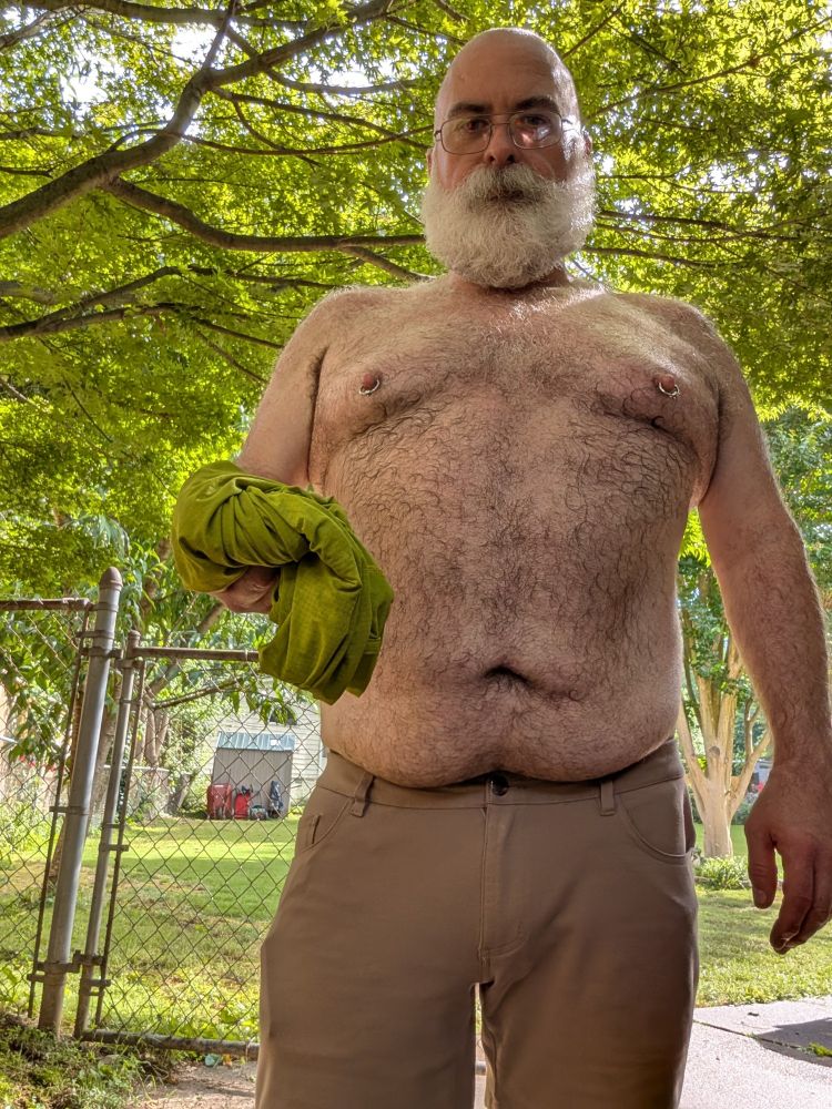 Hairy man holding his shirt covered in sweat 

