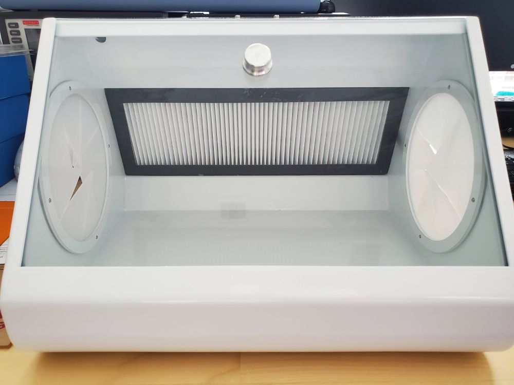 Front view of the box which shows the viewing glass as well as the filter in the back in front of the intake fans