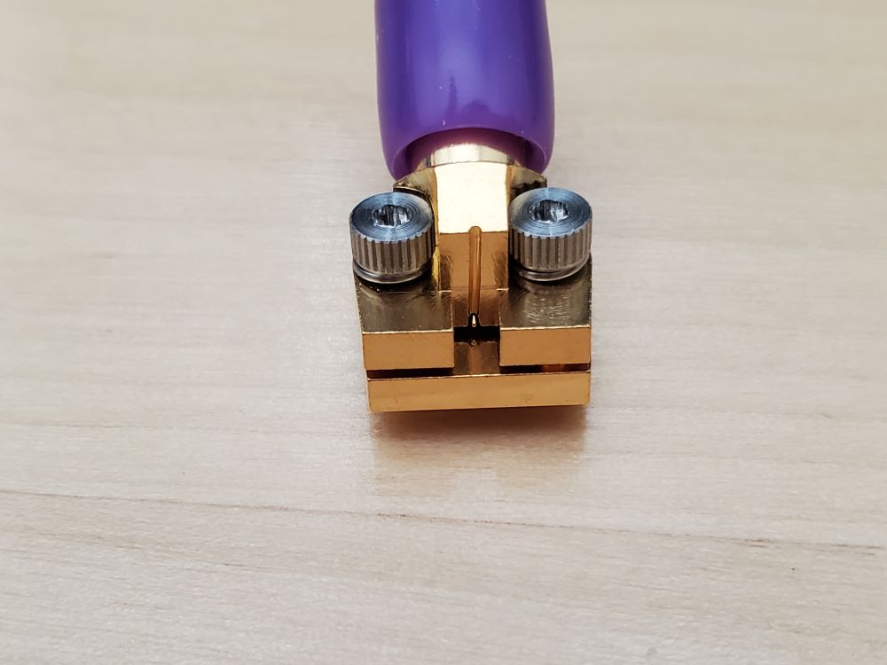 Connector back side with view of signal pin protruding just below the connector body but above the bottom mounting plate.