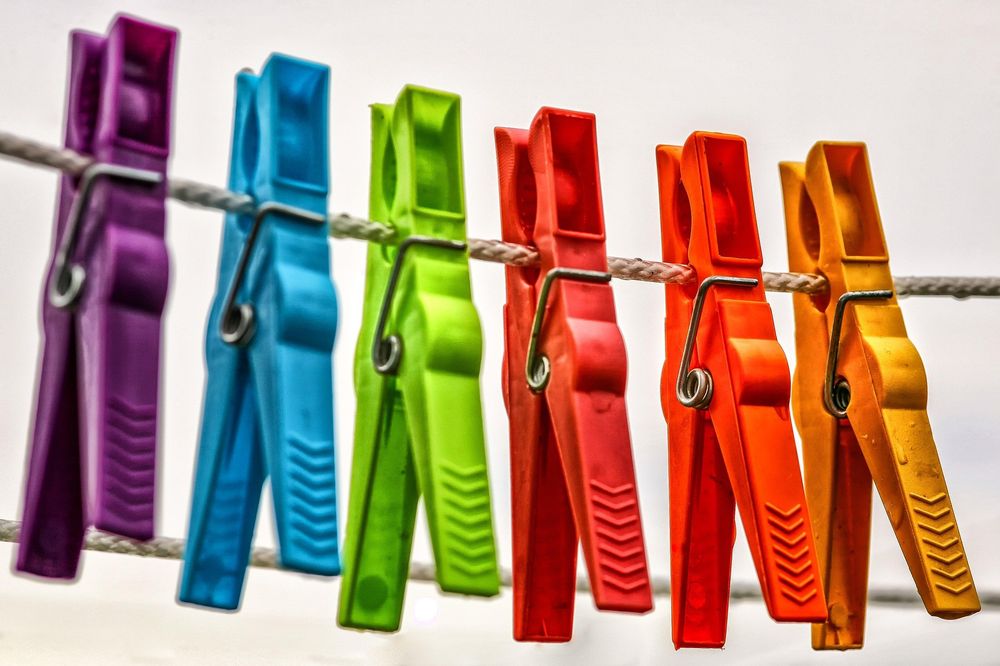 An image of coloured washing pegs hanging on a clothes line