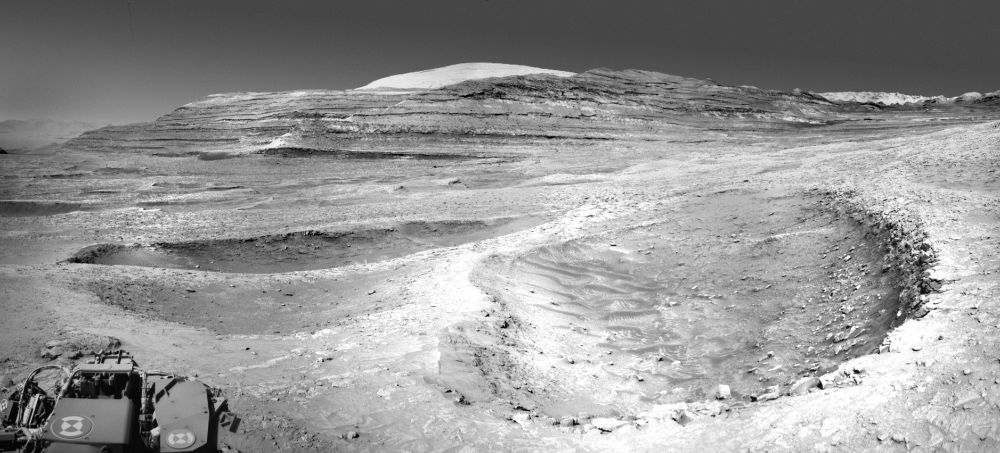 A rounded area of sandy pits are intersected by rocky ridges to form a peace sign shape on the Martian surface.