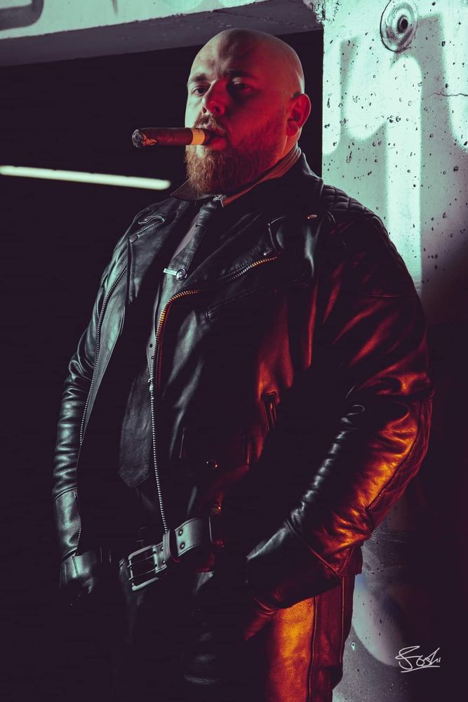 Man in leather in a car park.