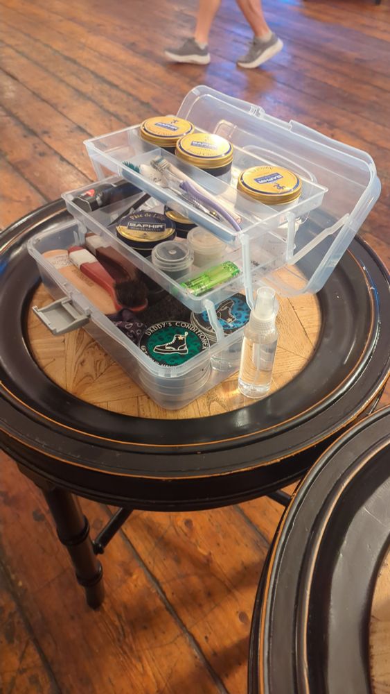 Table with various bootblacking equipment on top of it, awaiting use.