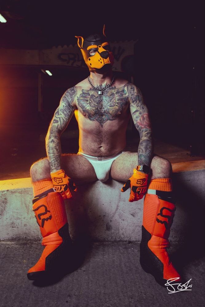 Human pup in just orange pup hood, white jock and orange MX boots. 
