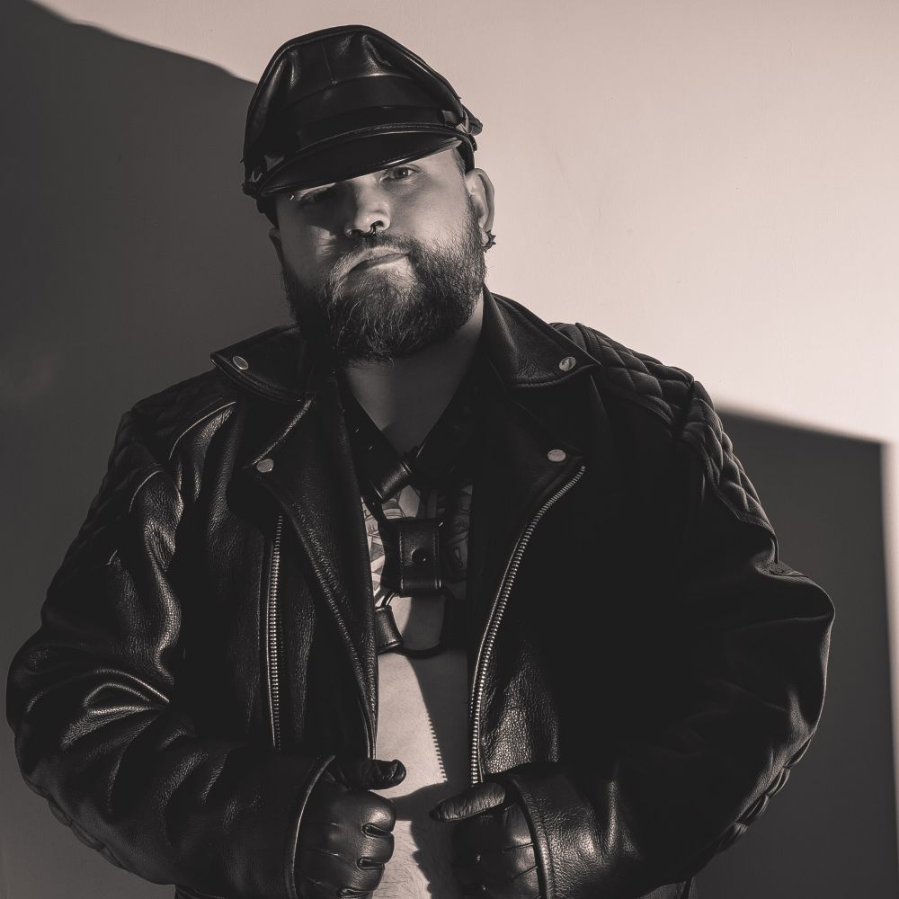 Leatherman wearing jacket, harness and gloves.