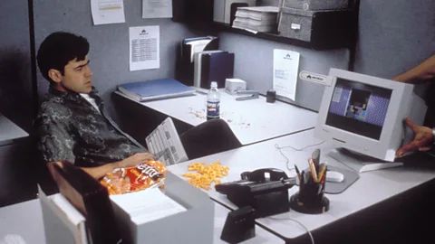 A still from Office Space. Peter Gibbons sits in his office. 