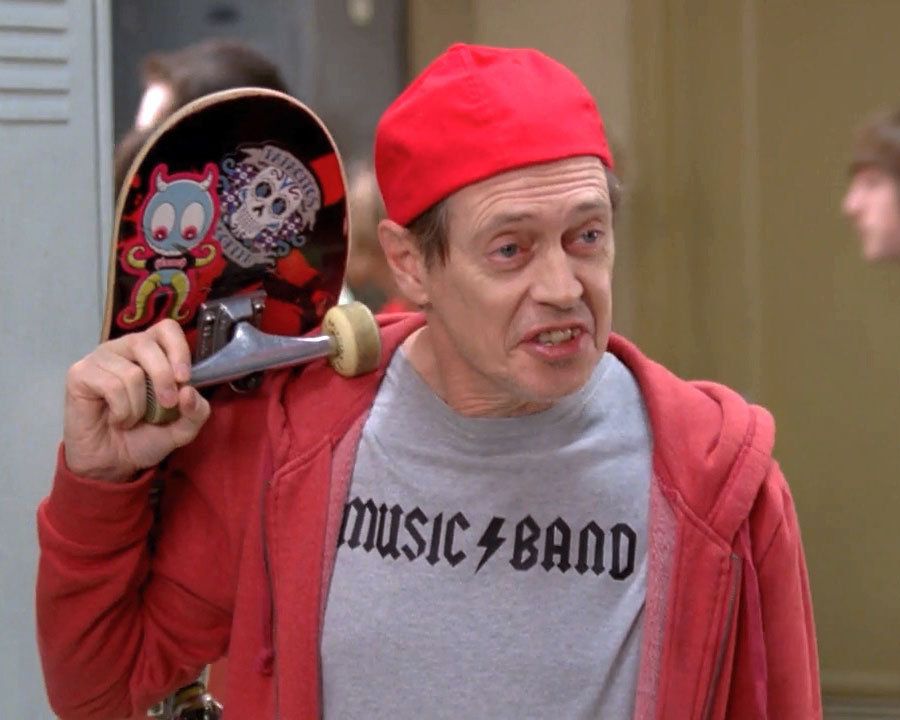Steve Buscemi dressed youthfully and holding a skateboard