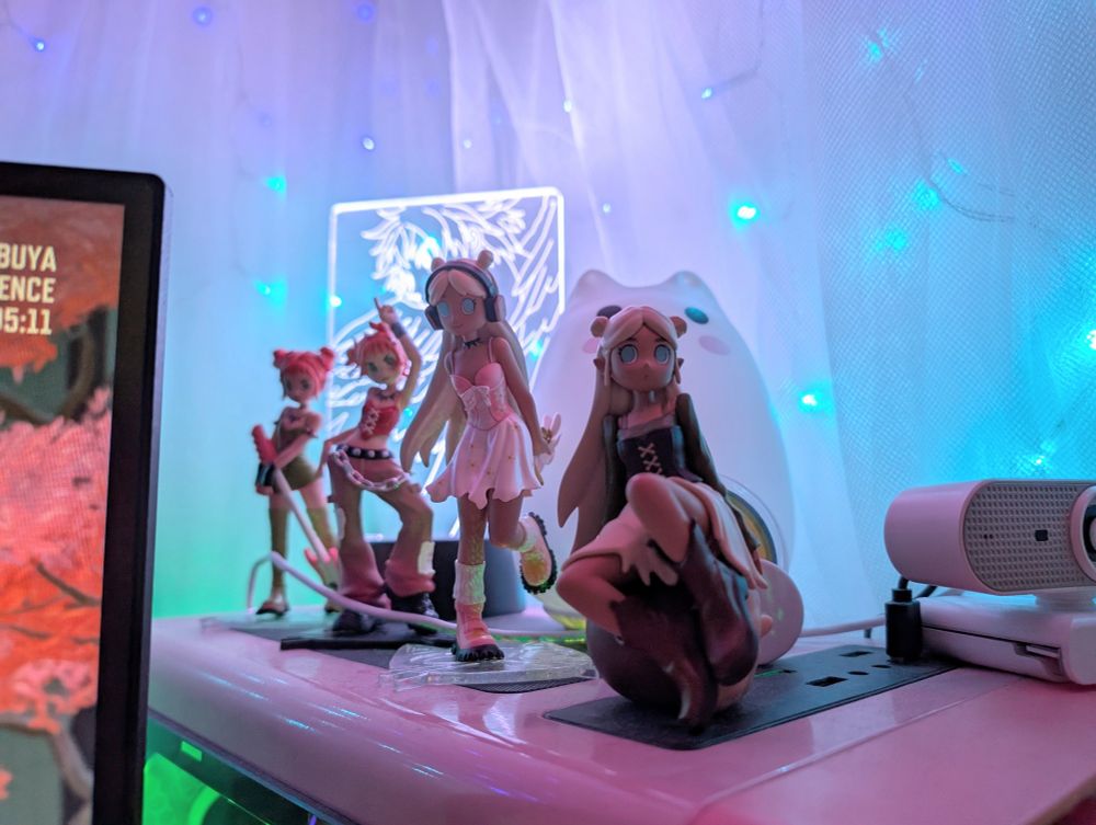 four peach riot figures on top of a pc