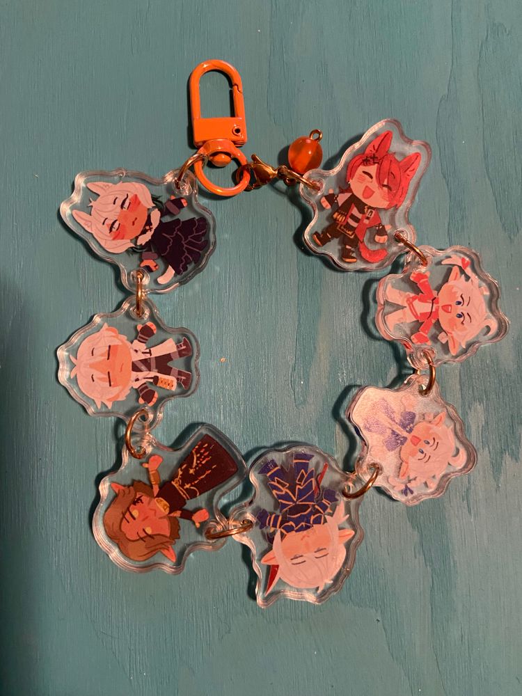 keychain charm from previous photo, it’s the scions from FFXIV in a circle, holding hands like a charm bracelet. It is extremely cute. In clockwise order it’s G’raha Tia, Alisaie, Alphinaud, Estinien, Urianger, Thancred, and Y’shtola, with an orange clasp and orange bead between Y’shtola and G’raha