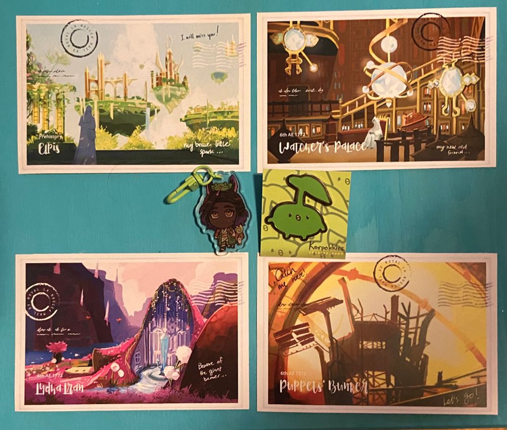 4 FFXIV location postcards - Elpis, Watcher’s Palace, Lydia Lran, and The Puppet’s Bunker, as well as a little Erenville keychain with a green clasp and a korpokkur enamel pin