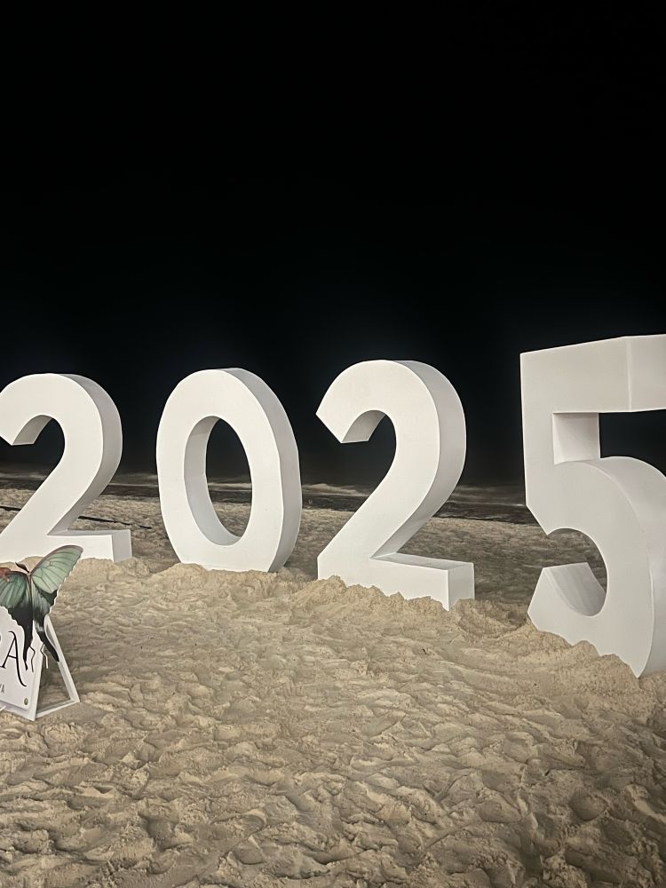 A sign on a beach that says 2025